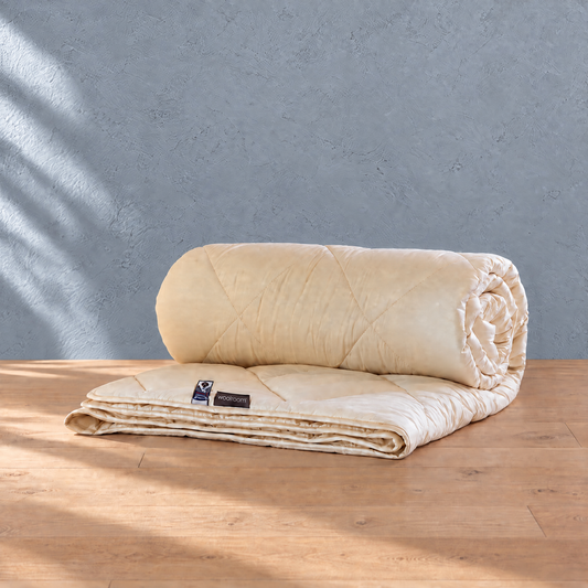 Woolroom Organic Washable Wool Duvet partly rolled on a wooden floor